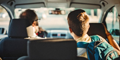 Junge fährt mit seinem Vater im Auto zur Schule