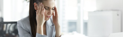 Frustrierte Frau sitzt im Büro – Kündigungsgrund