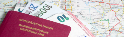 Deutscher Reisepass mit Euro-Scheinen auf Straßenkarte