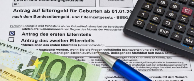 Urteil: Elterngeld zählt bei Hartz IV als Einkommen. Auf einem Antrag auf Elterngeld liegt ein Taschenrechner, einer blauer Kugelschreiber und Banknoten.